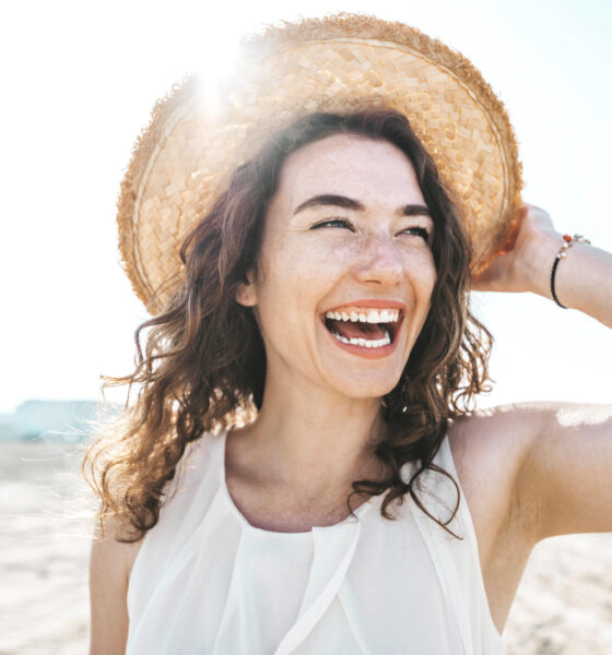 Happy beautiful young woman smiling at the beach side - Delightful girl enjoying sunny day out - Healthy lifestyle concept with female laughing outside